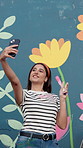 Happy woman, paintbrush and wall art with selfie for photography, picture or mural activity. Female person, painter or volunteer with smile or creativity for memory, charity or community service