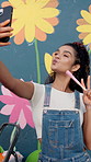 Happy woman, paintbrush and wall art with peace sign for selfie, photography or picture of mural activity. Female person, painter or volunteer with smile for memory, charity or community service