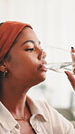 Home, woman and glass with water for wellness, hydration and benefits for gut health in living room. House, lounge and female person with h2o drink for thirst, detox or nutrition on sofa in apartment