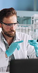 Science, liquid and man with beaker and microscope for research, medical analysis and chemistry in lab. Healthcare, biotechnology and scientist with solution for sample, experiment and development