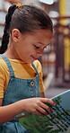 Smile, child and student with reading book in library for knowledge, fantasy story and language development. Kid, novel and study for academic growth, research and literature information of education