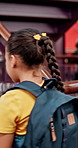 Girl, student and walking with backpack in library stairs for knowledge, education or learning. Back view, elementary or academic journey with bag for childhood development, books or novels at school