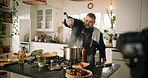 Camera, cooking and man in kitchen with meal, dinner or recipe online with content creation. Food, recording and male chef influencer with equipment for live streaming with diet advice in home.