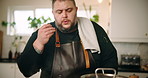 Man, chef and kitchen with food on stove for meal preparation, curry or stew at home. Male person, cook or blow with ingredients, taste or sauce for catering service, hospitality or recipe at house