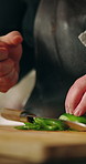Hands, pepper and wooden board with wrist pain for cooking, organic ingredients or carpal tunnel with burnout. Person, knife and vegetables with stretching, recipe or nutrition with arthritis in home