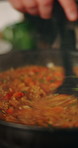 Hands, pan and chef with cooking, sauce and closeup in kitchen for diet, cuisine or culinary skills. Person, stove and prepare with recipe, ingredient and stir food with nutrition with meal in home
