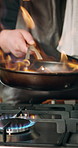 Cooking, hand and pan in kitchen with flame, culinary skills and technique process. Man, chef and fire in skillet for gourmet meal, food preparation and enhance flavor of cuisine in restaurant