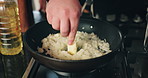 Hands, person and cooking food in kitchen for meal preparation, technique and risotto recipe. Chef, butter ingredient and rice dish with culinary skills, nutrition dinner and gourmet cuisine at house