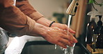 Home, washing hands and man in kitchen, cleaning and wellness with liquid to remove bacteria. Closeup, apartment and person with tap, faucet and water splash with healthy habit, safety and hygiene