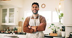 Arms crossed, cooking and face of man in kitchen of home for preparation of meal or supper. Apron, confident and smile of happy chef person in apartment for diet, healthy eating or nutrition