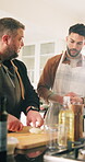 Chef, cutting and food with man in kitchen of home for cuisine or meal preparation. Cooking, demonstration and learning with people at counter in culinary course for diet, health or nutrition