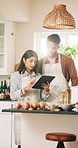 Couple, cooking and tablet with planning  in kitchen, conversation and recipe blog for nutrition or dinner. Man, woman and discussion with tech, support and help with talking for meal prep in home