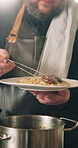 Man, hands and chef with plate of food in kitchen for cooking meal, hospitality or catering service. Closeup, male person or dish with pot, mushrooms or vegetables for dinner, cuisine or serving