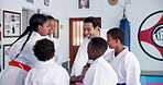 Support, student kids and karate teacher with hands together, huddle or motivation for martial arts education. Mission, training goals and learning self defense, man and children with unity in dojo