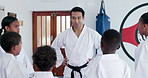 Teacher, students and karate class with talk for support, motivation and together for martial arts education. Mission, training goals and learning self defense, man and children with exercise in dojo