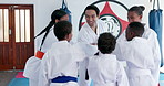 Support, student children and karate teacher with hands together, huddle or motivation for martial arts education. Mission, training goals and learn self defense, man and children with unity in dojo