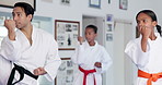Teaching karate, children and exercise in dojo for fight, fitness lesson or self defense class. Students, instructor and practice martial arts with man for workout, learning kick or kids training