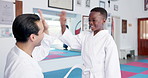 Man, teacher and high five with karate student in dojo for self defense training or preparation. Male person, sensei and mentor with kid, smile or belt for taekwondo practice, martial arts or start
