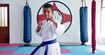 Boy, karate and ready with blue belt for martial arts training, self defense or fighting competition. Portrait, teenager or fighter preparation with strap or fist for taekwondo challenge in dojo