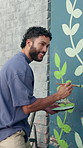 Man, painting and happy with mural on wall for flowers, art and design for community in urban town. Person, painter and smile with social responsibility, creative and volunteer for building in Mexico