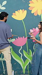Man, woman and painting with talk for mural with flowers, art and design for community in urban town. People, painter and back for social responsibility, creative and volunteer for building in Brazil