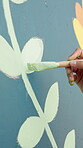 Hand, paintbrush and person painting of wall for floral design, creativity and DIY Earth day project with closeup. Painter, artist with flower or leaf mural with color, art and enviroment awareness
