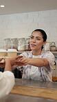 Happy, woman and customer in coffee shop, takeaway and purchase of hot beverage, barista or morning. Hospitality, consumer and server with package in small business, people and smile for sale in cafe
