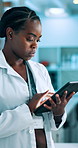 Research, science and black woman in lab, tablet and typing with report for pharmaceuticals results. African person, employee and scientist in workplace, tech and digital app for vaccine development