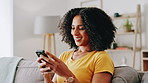 Woman, smile and typing with phone on sofa for social media post, streaming service and text message response. Home, african person and smartphone for app download, email notification or reading chat