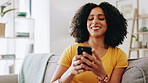 Woman, happy and typing with phone on sofa for dating site chat, social media post and text message response. Home, african person and smartphone for internet search, email notification and streaming