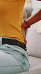 Back pain, hands and posture with person on sofa in living room of home for injury or massage. Accident, muscle fatigue and spine with woman closeup in apartment for inflammation or physical recovery