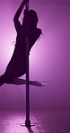 Nightclub, silhouette and pole dancer in spotlight for private performance, spin or flexible movement at neon party. Night, woman or burlesque performer on stage for entertainment, balance or dancing
