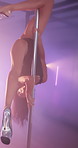 Woman, pole dance and balance at nightclub, flexible or creativity with neon, art and performance at concert. Person, exotic dancer and legs for private show, stretching or fantasy on stage in smoke