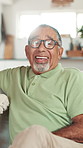 Face, home and old man with smile, funny and happiness with retirement, laughing and humor in lounge. Portrait, mature person and pensioner on sofa, joke and wellness with weekend break and relax