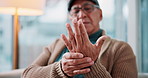 Arthritis, medical and senior man with hand pain, injury or muscle sprain in living room at nursing home. Osteoporosis, parkinson disease and closeup of elderly male person with wrist inflammation.