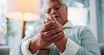 Arthritis, sofa and senior woman with hand pain, injury or muscle sprain in living room at nursing home. Osteoporosis, parkinson disease and closeup of elderly female person with wrist inflammation.