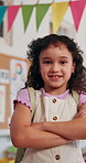 Face, confidence and happy kid in school for education, learning and future development. Portrait, smile and girl child in class with arms crossed for growth, scholarship and student in elementary