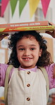 Face, kid and books on head in classroom for language development, literature and ready for story lesson. Balance, girl student and happy with textbooks at school for academic knowledge and learning