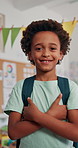Face, smile and kid in school for learning, education or youth development. Portrait, happy boy and confident child in class with arms crossed for growth, scholarship or African student in elementary