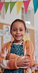 Face, smile and child in school for learning, education or youth development. Portrait, happy girl and confident kid in class with arms crossed for growth, scholarship or elementary student in Spain