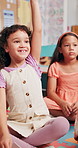 Happy, student and child with answer in classroom, growth and development with knowledge and learning. Elementary, group and girl with smile for education, back to school and hand up for question