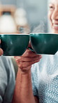 Hands, coffee and celebration with toast in home for senior couple with anniversary, love and connection. People, mug and cheers with drink, tea or latte in retirement with bonding in living room