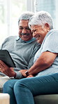 Elderly couple, tablet and laugh on couch in home pictures, memory or funny video on web in living room. People, man and woman on digital touchscreen with app, streaming or social media in retirement