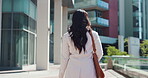 Back, business and woman walking in city for travel, journey and morning commute as relator. Female person, sidewalk and adventure for corporate career, trip route and routine for architecture view