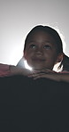 Smile, watching and child with movie in cinema for entertainment with bright light. Happy, cute and young girl kid in theater streaming cartoon film, show or series at night with empty seats.