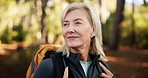 Hiking, senior woman and walking in forest for adventure, retirement hobby and cardio wellness. Mature person, thinking and journey with backpack for trekking, explore or holiday sightseeing in woods