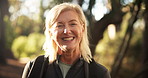 Hiking, mature woman and face in woods for adventure, retirement hobby and cardio wellness. Senior person, smile and portrait with backpack for trekking, explore and holiday sightseeing in forest