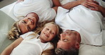 Above, relax and bedroom with parents, girl and bonding together with family, love and morning. Happiness, mother and father on bed, daughter and smile with rest, support and chilling at home