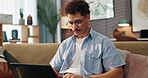 Sofa, man and typing with laptop for freelancer, research information and news story for publication. Home, remote work and content writer with digital for blog website, online article and editing