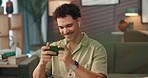 Man, phone and earphones for video on sofa with movie surprise, streaming subscription and online channel. Relax, person and smartphone in home for web entertainment, internet show or watching series